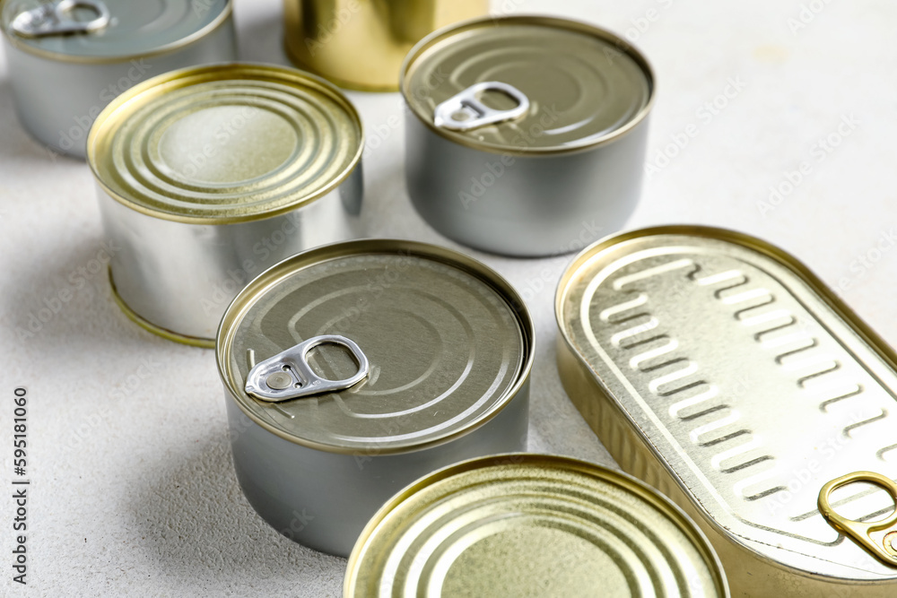 Assortment of tin cans with fish on white table Assortment of tin cans with fish on white table