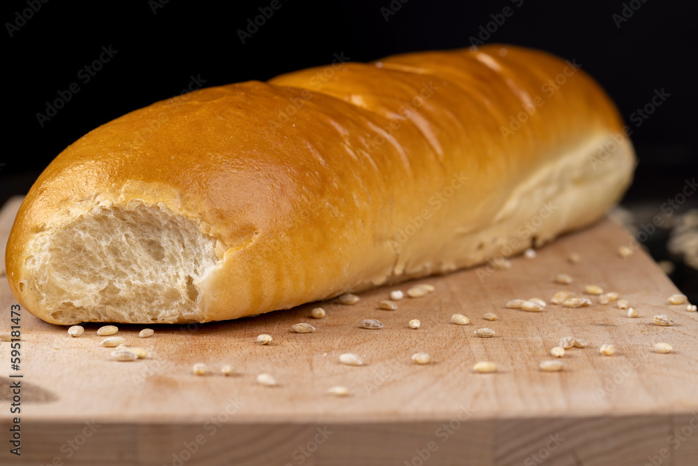 Wheat baguette on a wooden cutting board