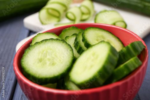 Bowl with pieces of fresh cucumber on table, closeup