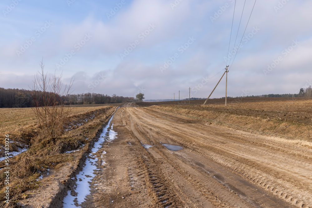 a broken country road at the beginning of spring