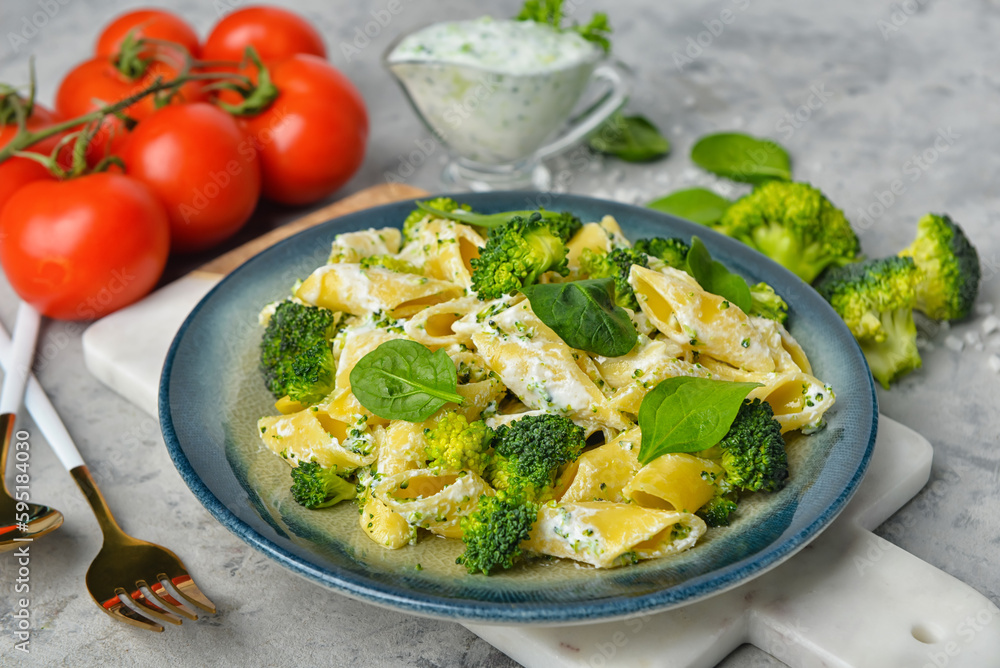 Plate with tasty pasta and broccoli on grey grunge background Plate with tasty pasta and broccoli on grey grunge background