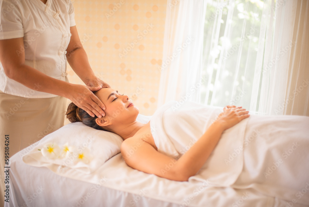 Side view of beautiful asian woman let a professional masseuse massage her head with pleasure. Side view of beautiful asian woman let a professional masseuse massage her head with pleasure.