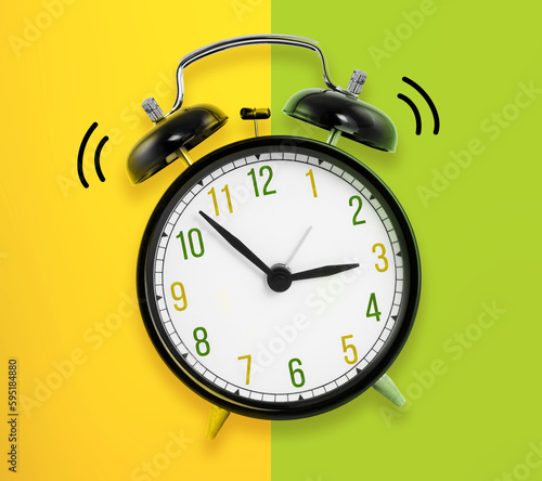 Old black clock on green and yellow background