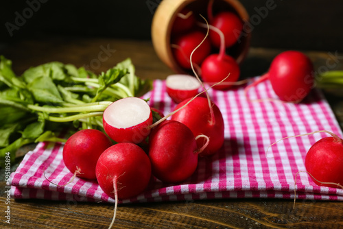 Ripe radish with green leaves on table, closeup