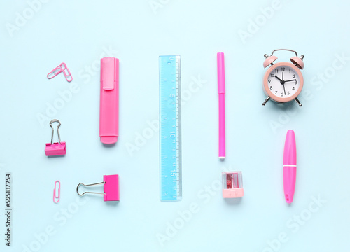 Clock and stationery supplies on blue background