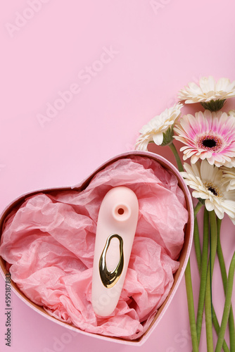 Fototapeta Naklejka Na Ścianę i Meble -  Gift box with vibrator and flowers on pink background