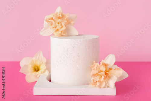 Decorative plaster podiums with flowers on pink background