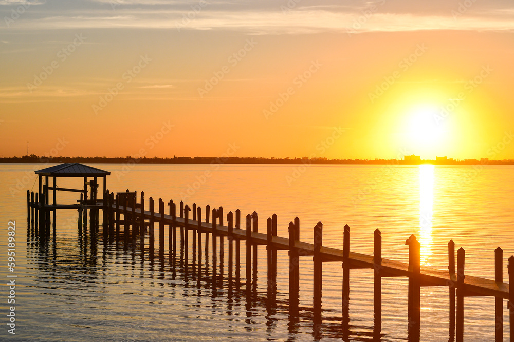 Long wooden dock at sunrise along the Indian River Lagoon in Brevard County, Florida