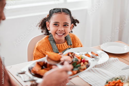 Family dinner, child and mother with vegetables serving at a home table with happiness on holiday. Food, house and happy eating of a girl with a smile at a gathering with a kid and mom at meal