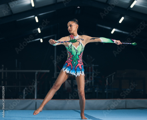Woman, gymnastics and sticks in gym for training, dancing and performance with creativity, balance and wellness. Female gymnast, athlete and dance for workout, sports and prepare for competition