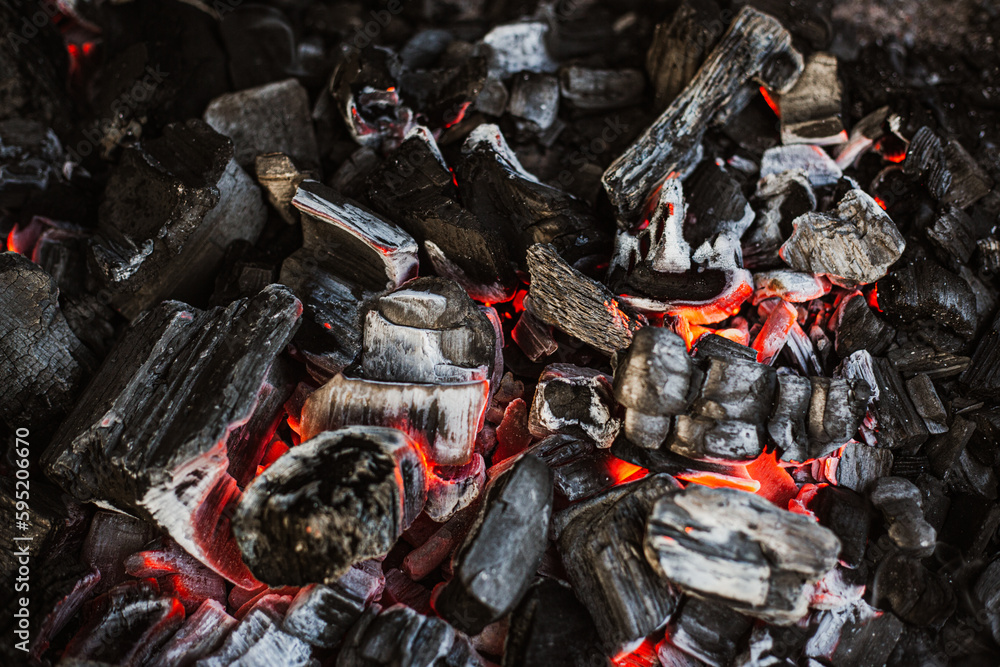 Burning charcoal for grilling close-up. Smoldering charcoal inside the grill gives heat for cooking pickled meat, barbecue, steak, vegetables, barbecue.