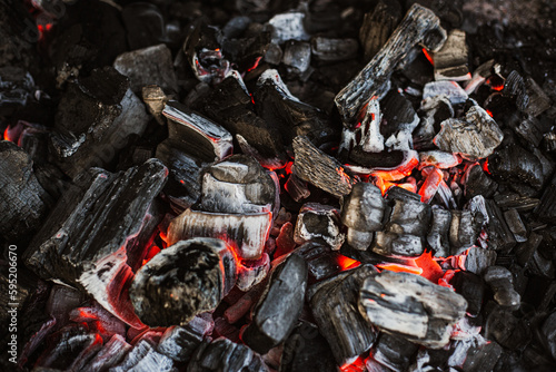 Burning charcoal for grilling close-up. Smoldering charcoal inside the grill gives heat for cooking pickled meat, barbecue, steak, vegetables, barbecue.