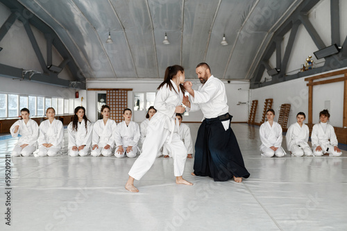 Aikido instructor teaching teenager fighters during group training in gym