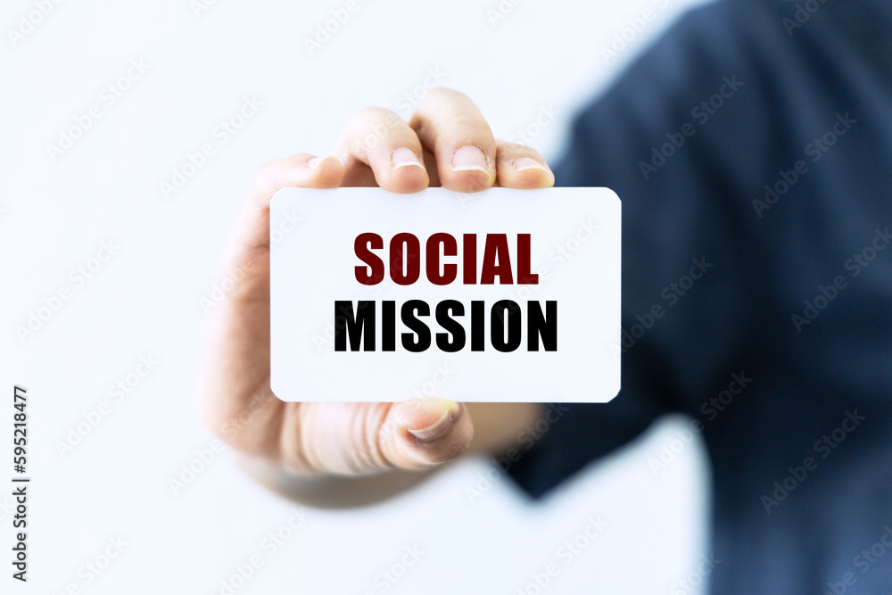 Social mission text on blank business card being held by a woman's hand with blurred background. Business concept about social mission. Social mission text on blank business card being held by a woman's hand with blurred background. Business concept about social mission.