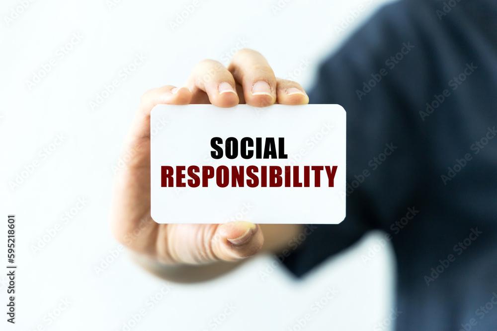 Social responsibility text on blank business card being held by a woman's hand with blurred background. Business concept about social responsibility. Social responsibility text on blank business card being held by a woman's hand with blurred background. Business concept about social responsibility.