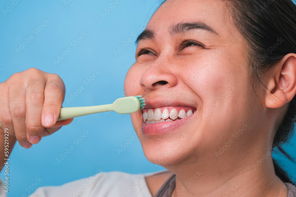Happy Asian woman taking care of her teeth and holding a toothbrush. Young lady brushing her teeth. dental care and oral hygiene concept. Happy Asian woman taking care of her teeth and holding a toothbrush. Young lady brushing her teeth. dental care and oral hygiene concept.