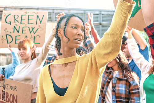 Hispanic woman incites crowd during a protest against global warming - Group of young people protesting to save the world