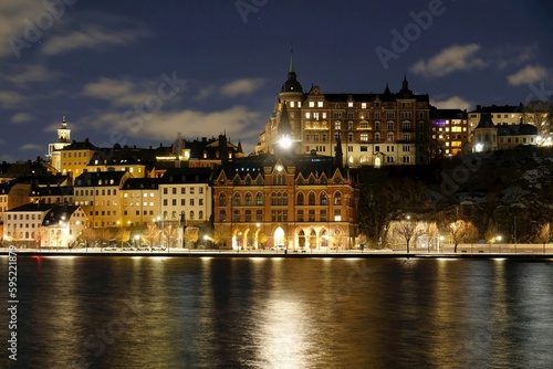 Beautiful scenery of illuminated Stockholm waterfront view towards Sodermalm district with historic Mariahissen building and Monteliusvagen, Sweden 