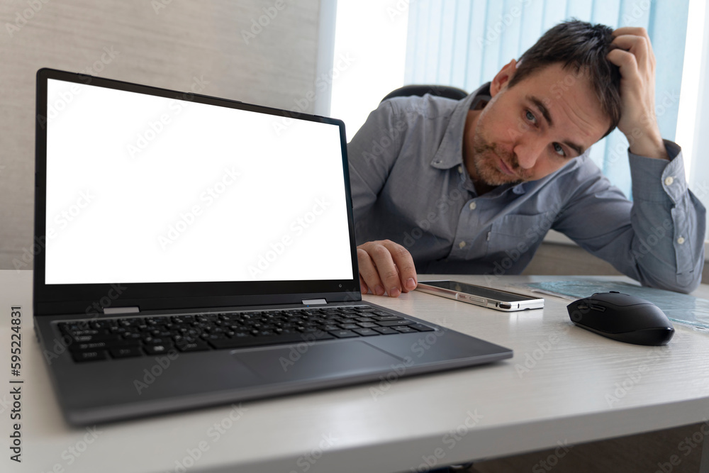 tired business man rubbing his head sitting at table in front of laptop in his office tired business man rubbing his head sitting at table in front of laptop in his office