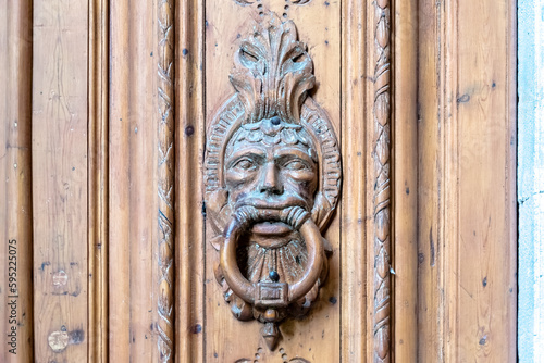 This close-up photo captures the intricate details of an ancient door knob on a gate in the Gothic Quarter, the historic heart of Barcelona's old city. 