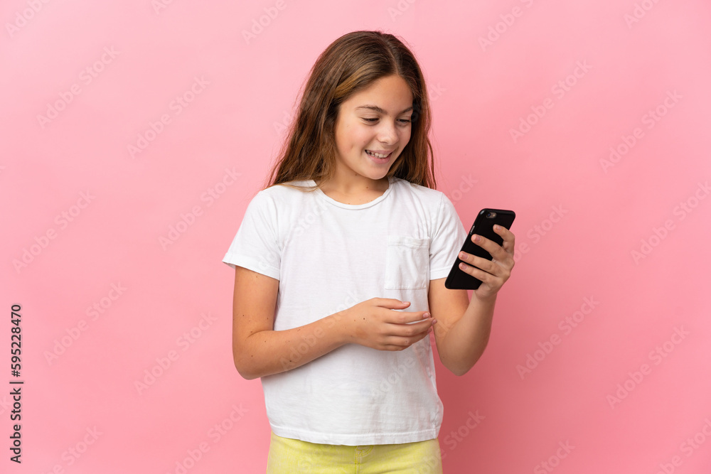 Child over isolated pink background sending a message or email with the mobile Child over isolated pink background sending a message or email with the mobile