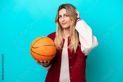 Young caucasian basketball player woman isolated on blue background having doubts © luismolinero