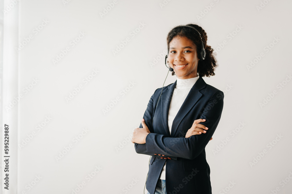 Serious call center operator in wireless headset talking with customer, woman in headphones with microphone consulting client on phone in customer support service in business center Serious call center operator in wireless headset talking with customer, woman in headphones with microphone consulting client on phone in customer support service in business center