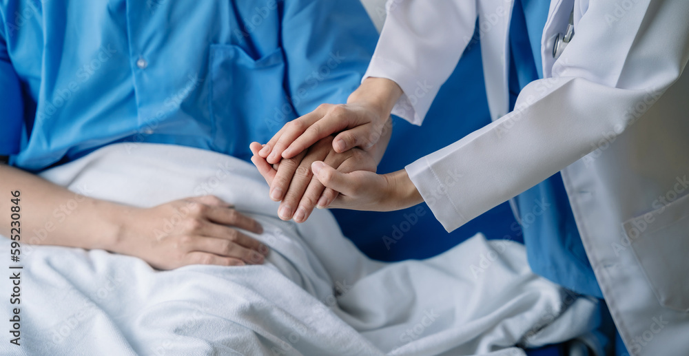 doctor talking with man patient for monitoring and check up after surgery. doctor touching patient hand and consoling. doctor talking with man patient for monitoring and check up after surgery. doctor touching patient hand and consoling.