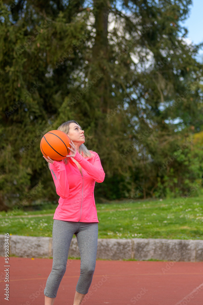 Woman playing basketball on a sports field Woman playing basketball on a sports field