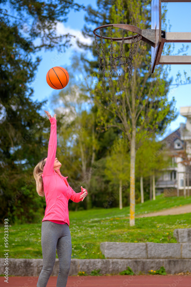 Woman playing basketball on a sports field Woman playing basketball on a sports field
