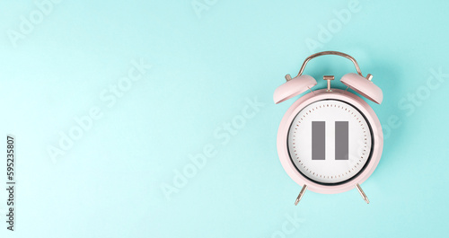 Alarm clock with pause sign, take a break, menopause concept, hormone replacement therapy