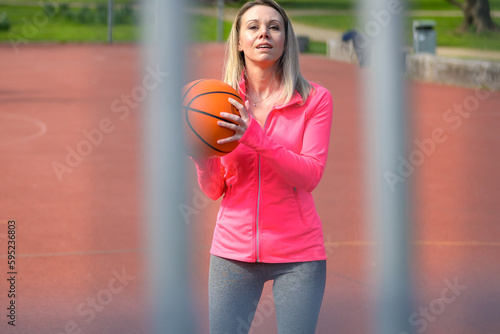 Woman playing basketball on a sports field