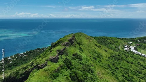 Aerial video of drone flying on the top of a tropical mountain showing the ocean