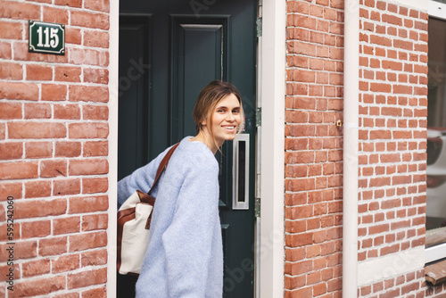 Photos Young pretty woman in casual outfit going out of house