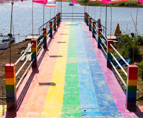 Wallpaper Mural Concrete Rainbow bridge in Thailand. Rainbow is symbol LGBTQ is term to refer to people of different gender is diverse group. View of colorful bridge extends into freshwater lake in bright sunlight.  Torontodigital.ca