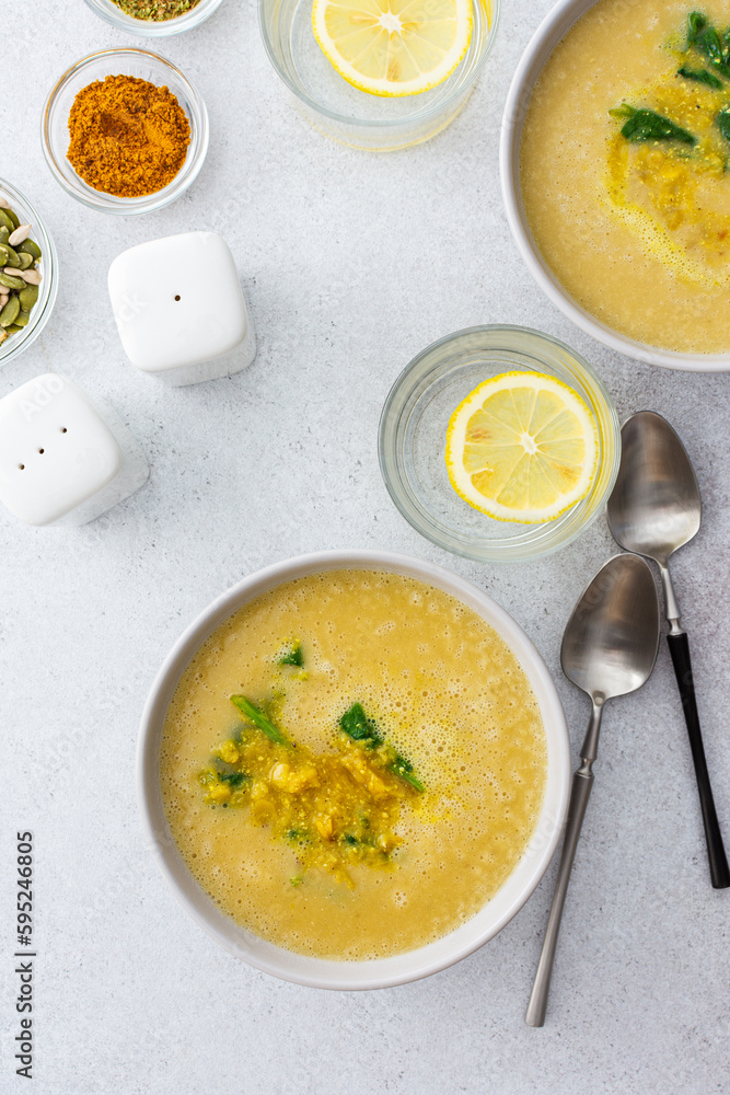 Healthy lunches, cream soup of yellow and orange lentils with fried onions and spinach leaves and curry, useful legums, top view Healthy lunches, cream soup of yellow and orange lentils with fried onions and spinach leaves and curry, useful legums, top view