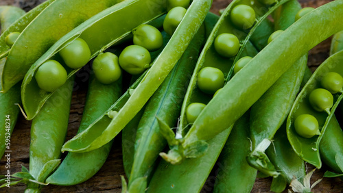 Green open pods of fresh peas on a wooden surface. Panorama. Freshly picked peas, vitamin, high-protein plant-based diet