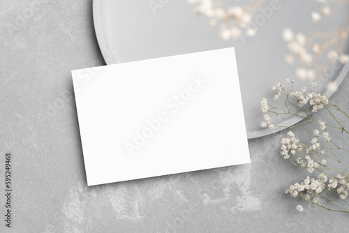 Blank save the date invitation card mockup with flowers decor on grey