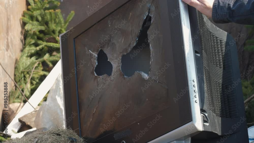 an old broken kinescope TV is thrown into the trash can. broken screen