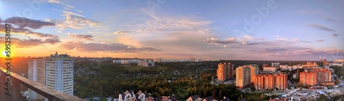 Beautiful sunset over the city filmed from a high floor of a house. Panorama of the city from above. photo