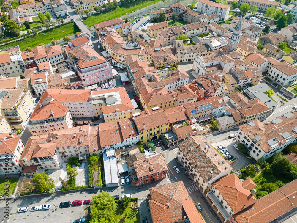Aerial shot of a small Venetian city. Red roofs, late spring and a river in sight.