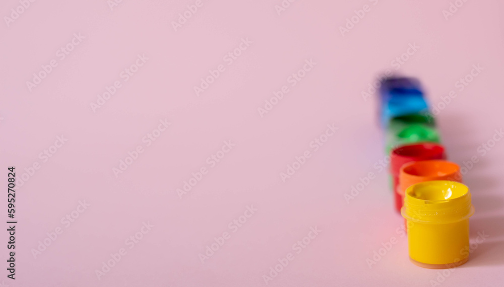 Multicolored paints on a pink background. Jars with multi-colored paints. Acrylic, gouache. Multicolored paints on a pink background. Jars with multi-colored paints. Acrylic, gouache.