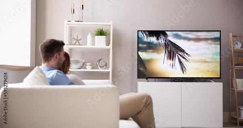 Rear View Of A Couple Watching Movie On Television