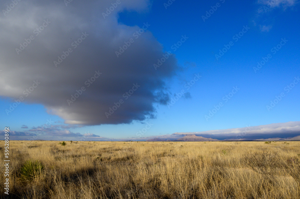 Cloud cover lifting over desert with mountain panorama