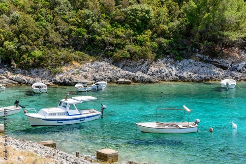 Boats anchored in cove with clear turquoise water at Rasohatica beach on Korcula island in Croatia