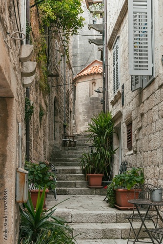 Narrow streets with stone houses and green plants in beautiful mediterranean old town of Korcula