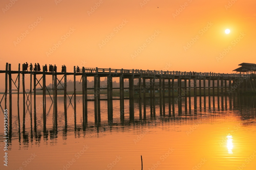 The silhouettes of monks on a bridge at sunset in Myanmar