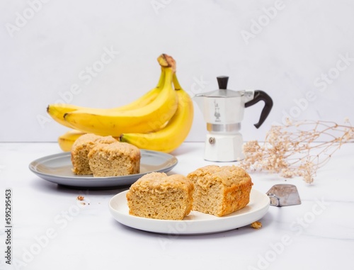 Moka pot and pieces of freshly baked banana cake on a marble table