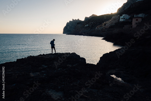 un homme se prom  ne sur le littoral. Balade pensive    Majorque. Silhouette d un homme au bord de la mer m  diterran  e. Admirer le paysage aux Bal  ares. Matin sur le littoral maritime. 