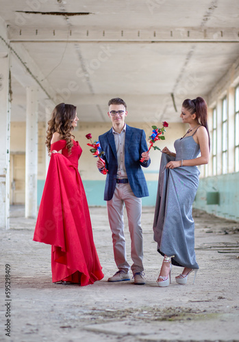 Teenage high school graduates ready for the prom. Boy giving roses to his dates